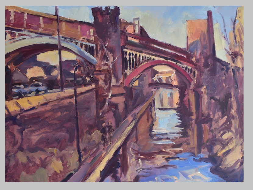 A view of a canal beneath a viaduct in Manchester
